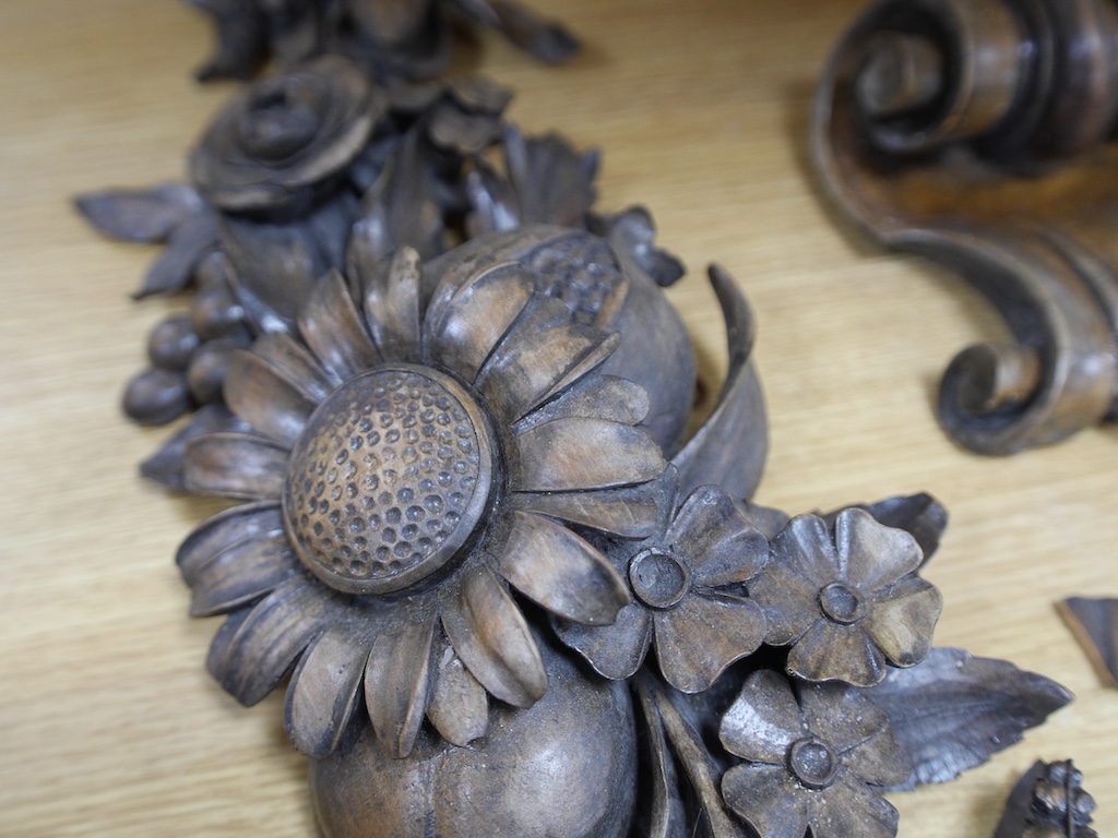 A pair of late 19th/early 20th century carved beech ‘fruit and flower’ wall appliqués and a similar corbel, 70cm long. Condition - fair